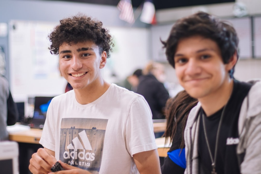Two young adult students smiling at the camera